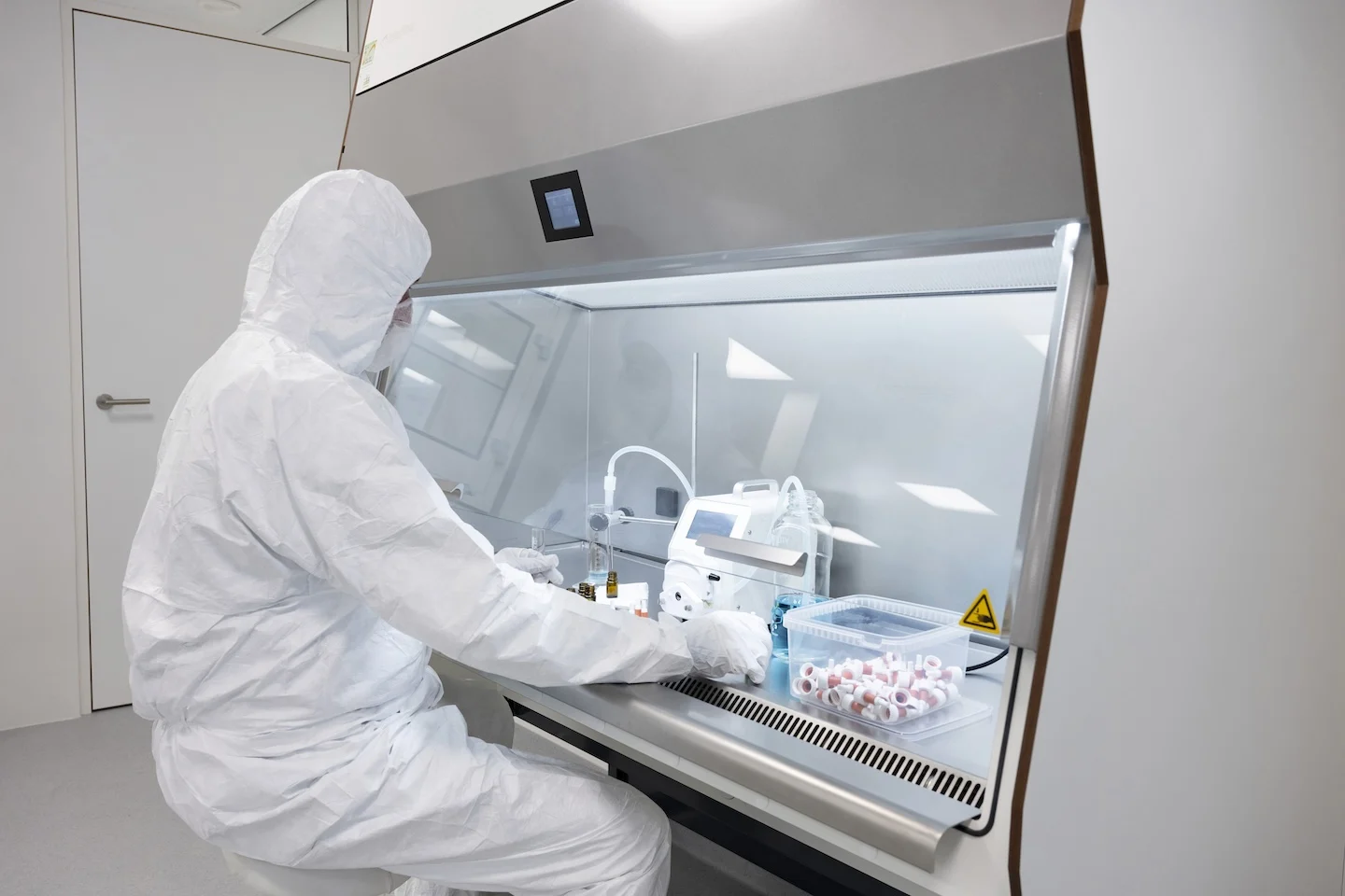 Apotheker werkt in isolator met beschermende kleding in een steriele omgeving